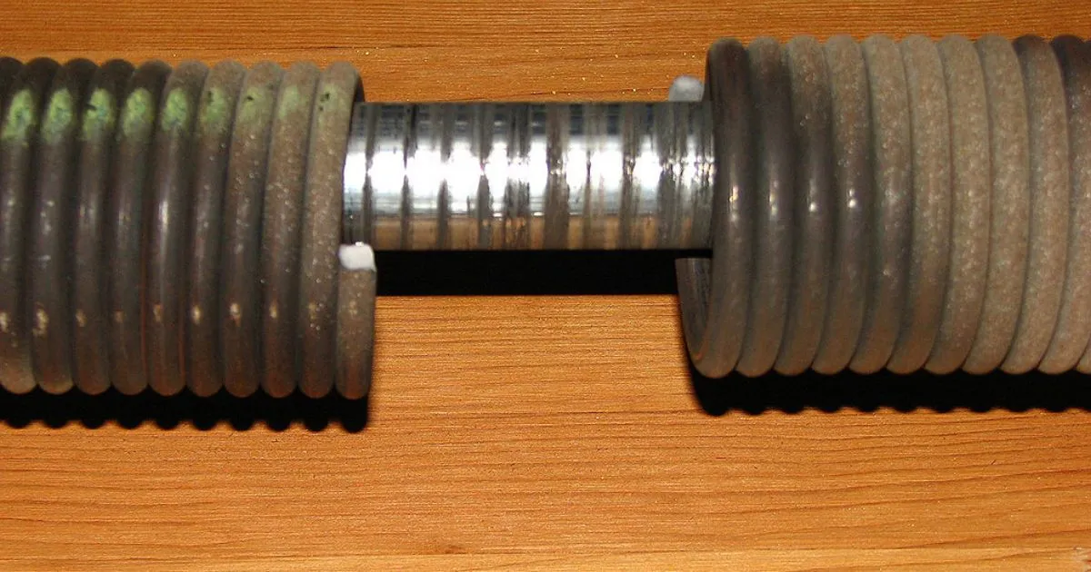 A close-up of broken garage door springs, indicating damage and dysfunction