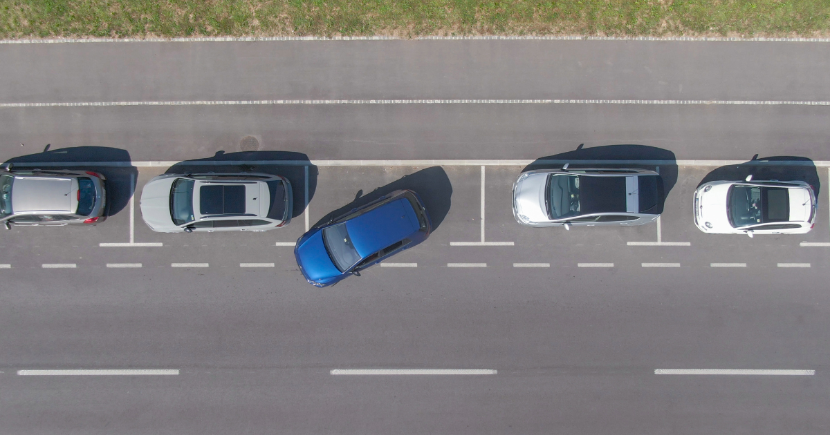 Person walking to find car park Cars parked on side of road