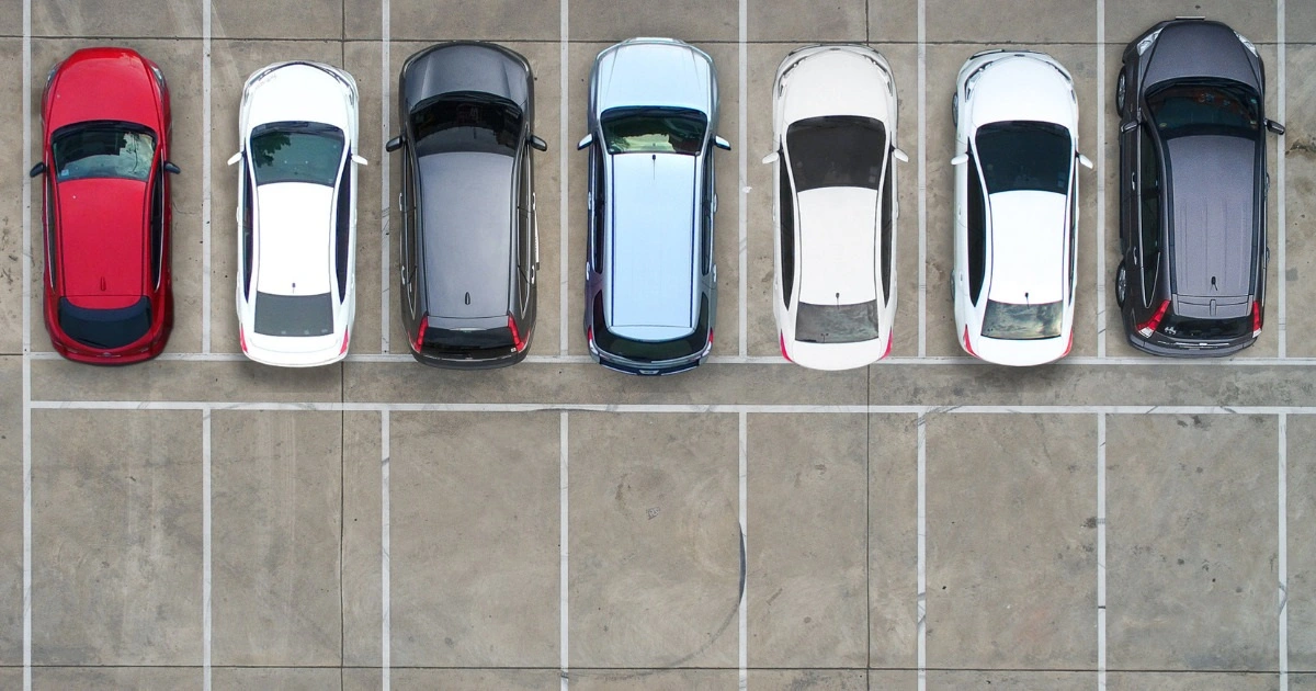 Multiple cars parked safely in an open parking lot