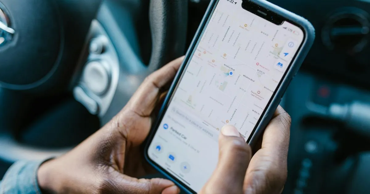 A Car Driver Uses His Phone To Navigate Parking Spaces