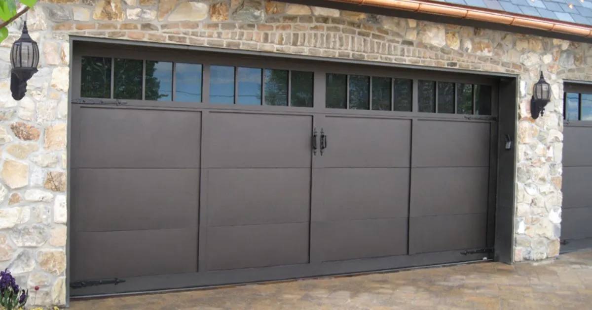 A Closed Black Garage Door With Some Glass Work In It