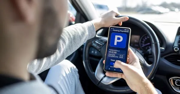 A Driver Booking And Paying For Parking Via His Phone Using Parking App