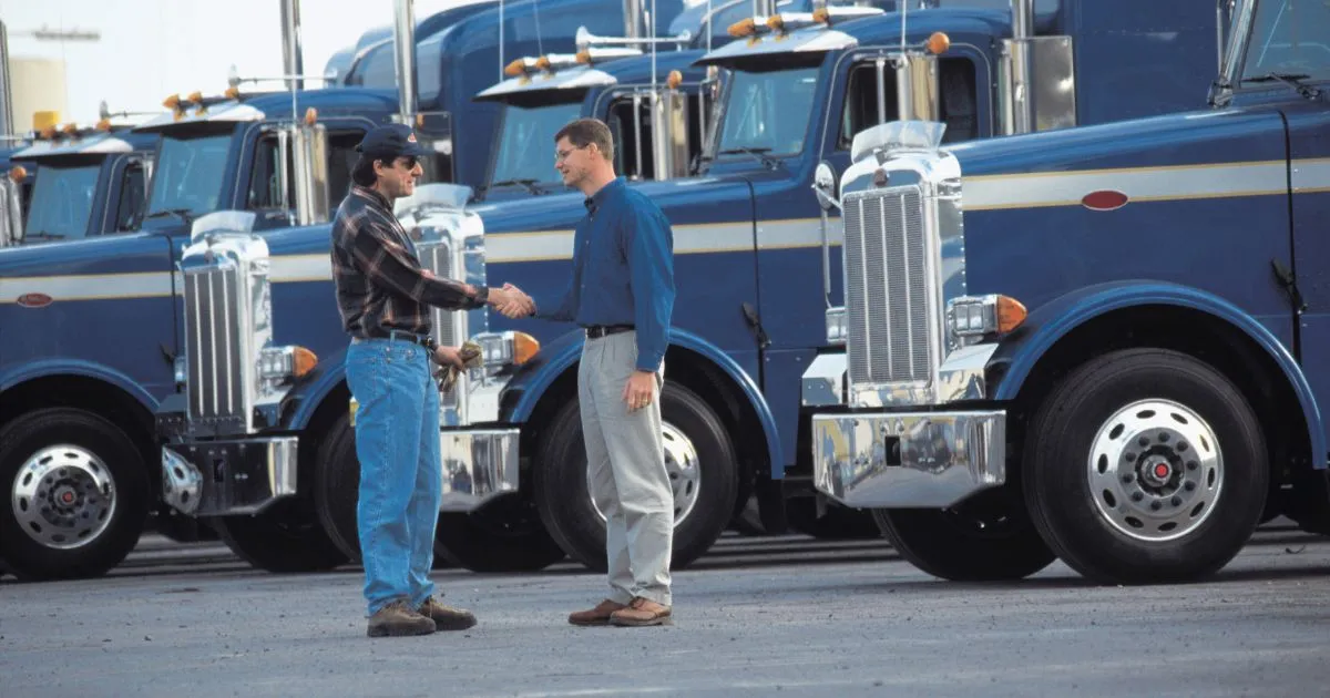 A Fleet Of Trucks Parked In A Vast Parking Lot
