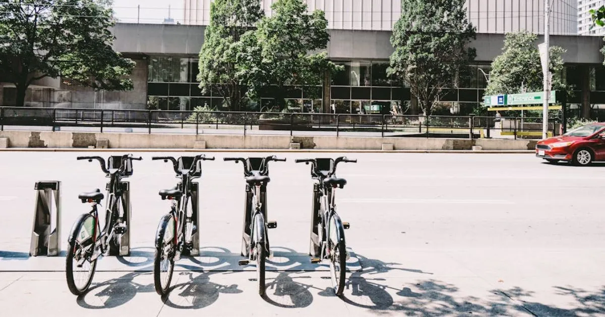 A Green Parking Lot Having Four Bicycles Parked In It