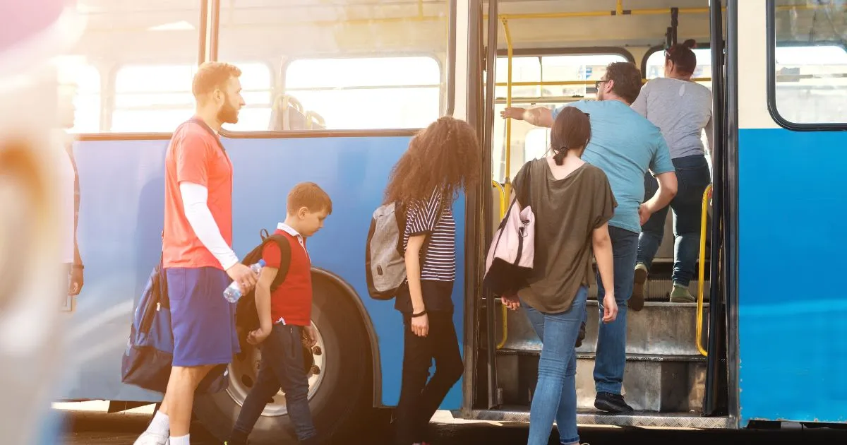 A Group of People Entering An Electric Bus For Their Daily Commute