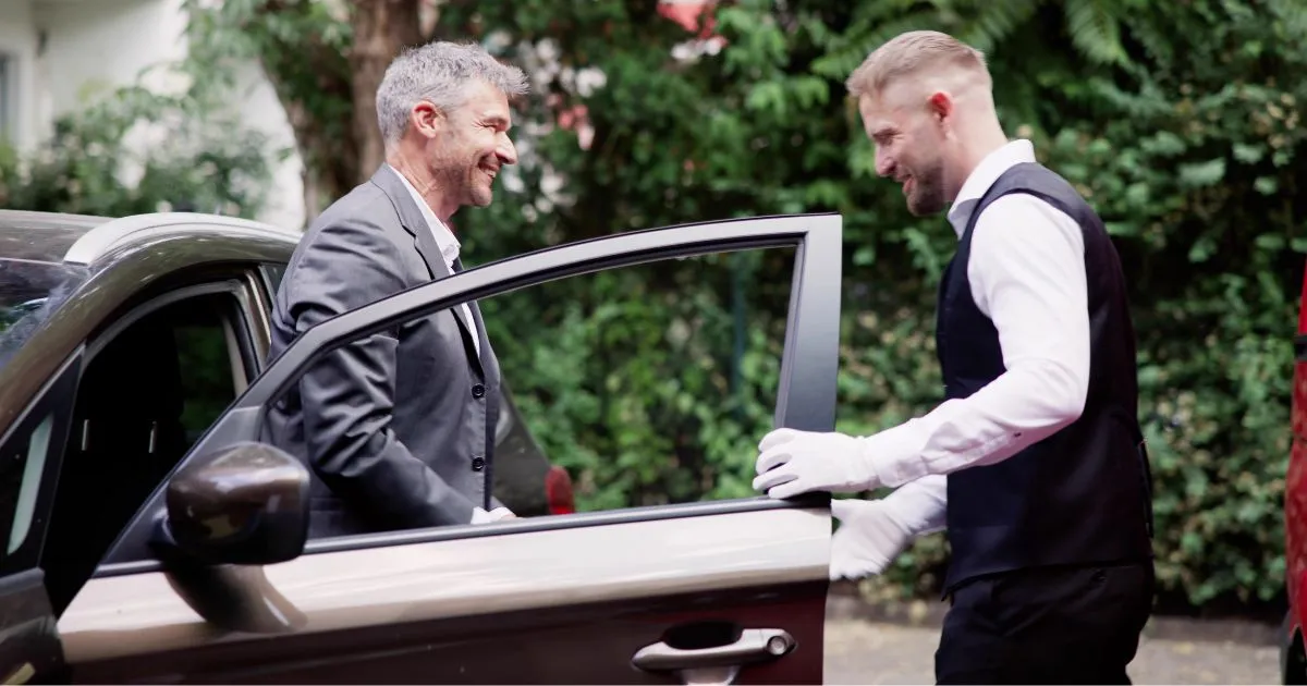 A Guest Stepping Out Of His Car Giving Charge To Valet Attendant