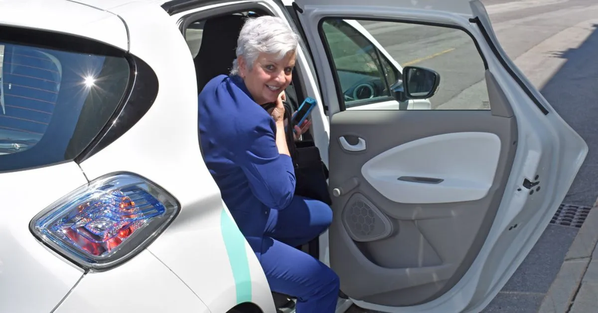A Lady Posing To The Camera While Leaving A Shared Autonomous Vehicle