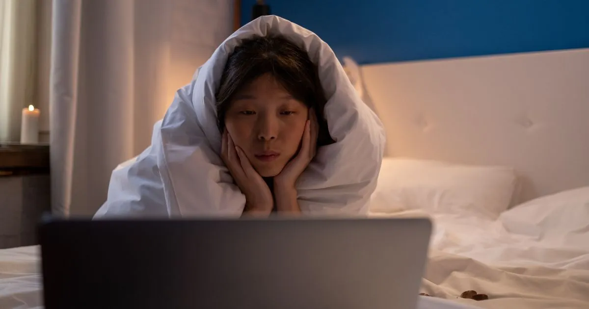 A Lady Watching A Horror Movie On Her Laptop