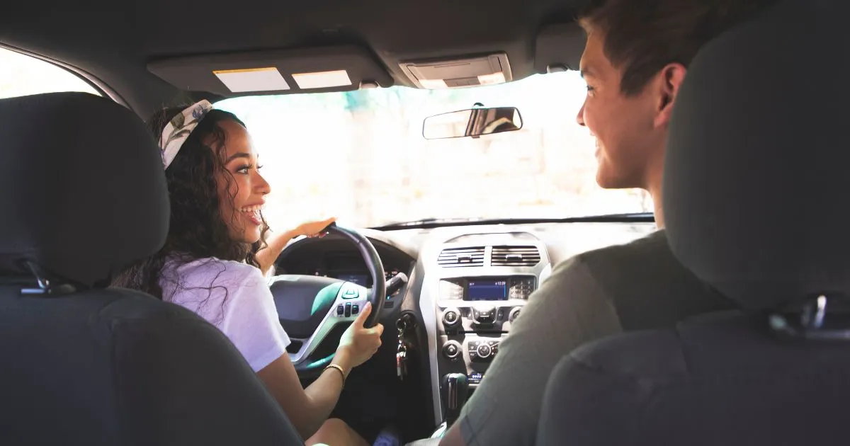 A Male And A Female Sharing A Ride In A Car