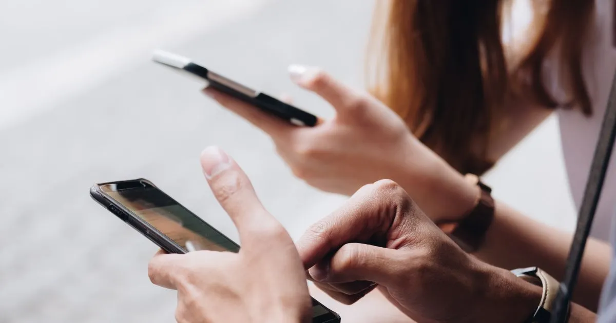 A Male And Female Using Their Phone To Find And Book Parking For Their Vehicles
