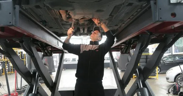 A Man Repairing His Car In A Modern Workshop A Man Repairing His Car In A Modern Workshop