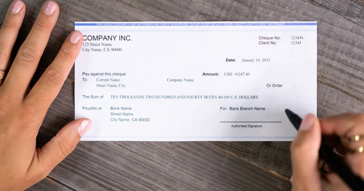 A Man Signing A Money Order