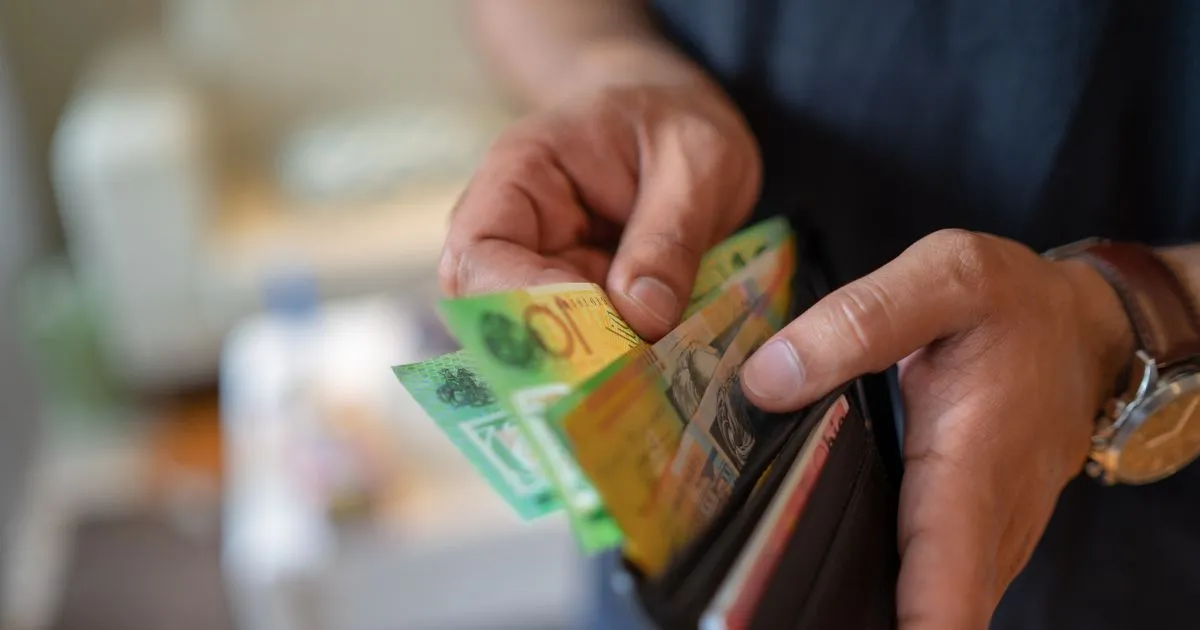 A Man Taking Money Out Of His Wallet To Pay To A Landlord As A Key Deposit
