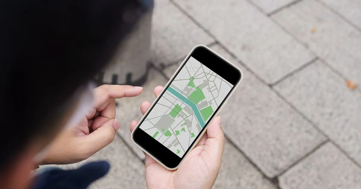 A Man Using His Phone To Search Parking On Google Maps
