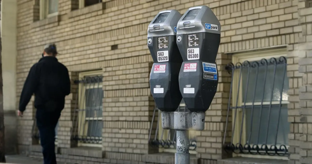 A Man Walking By A Digital Parking Meter That Allows Drivers To Track And Pay For Parking