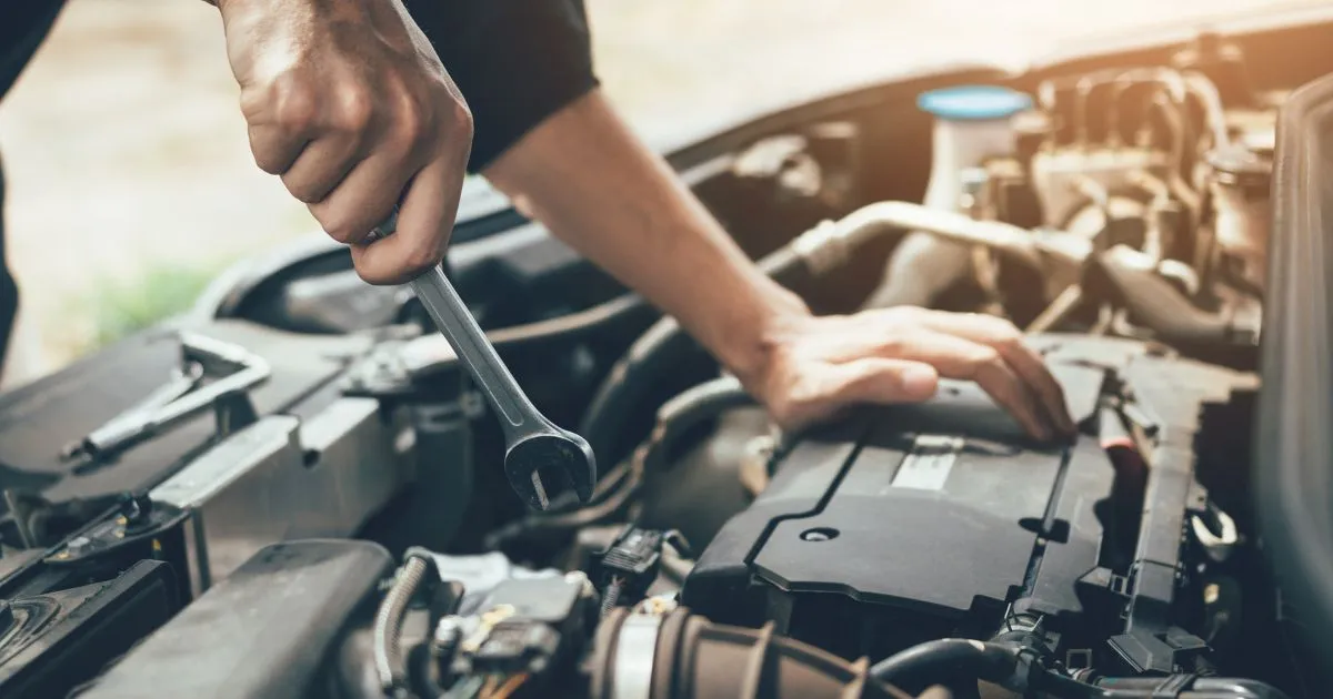 A Mobile Mechanic Working On A Car's Broken Engine A Mobile Mechanic Working On A Car's Broken Engine