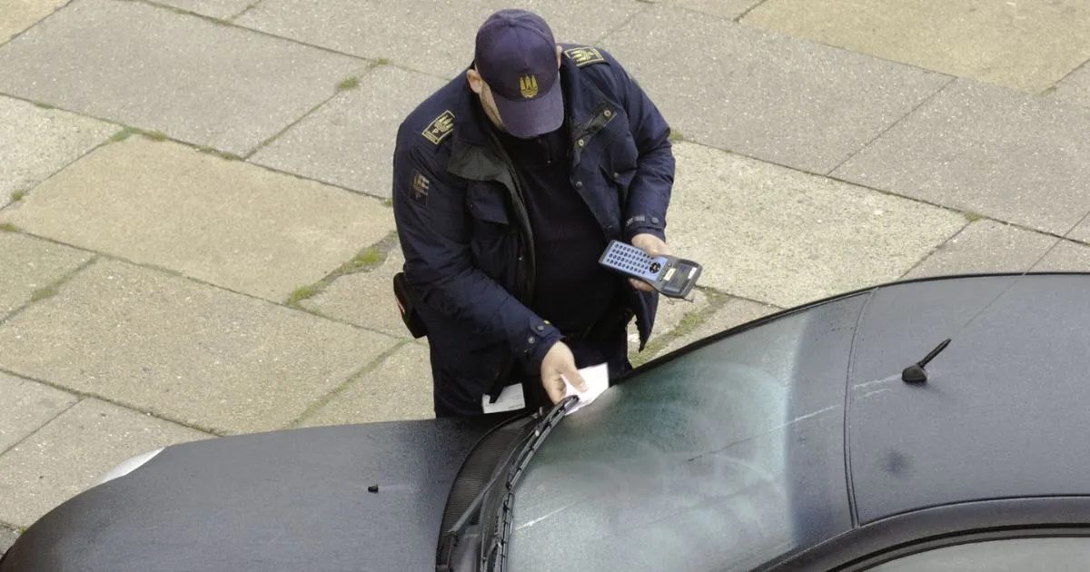 A Parking Officer Handing Over A Parking Ticket To A Car Driver