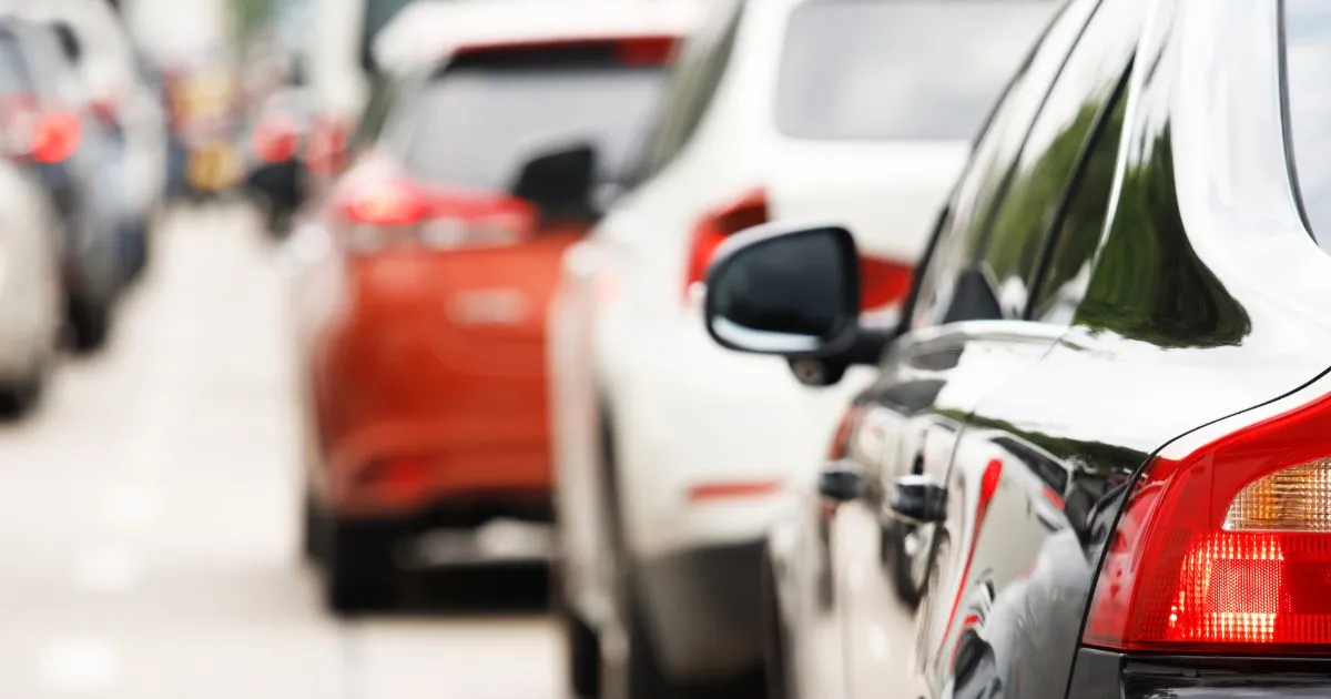 A Queue Of Cars In A Parking Lot Moving Towards The Covered Parking Area A Queue Of Cars In A Parking Lot Moving Towards The Covered Parking Area