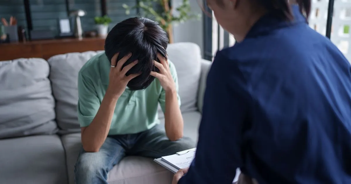 A Stressed Adult Holding His Head With His Hands