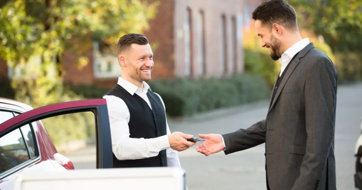 A Valet Attendant Handing Over Car Keys To The Owner
