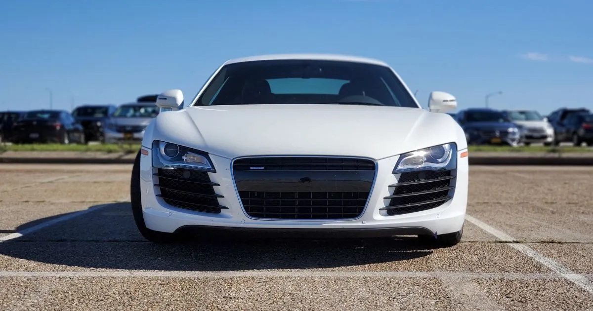 A White Car Parked In An Outdoor Parking Space For Employees Of A Business A White Car Parked In An Outdoor Parking Space For Employees Of A Business