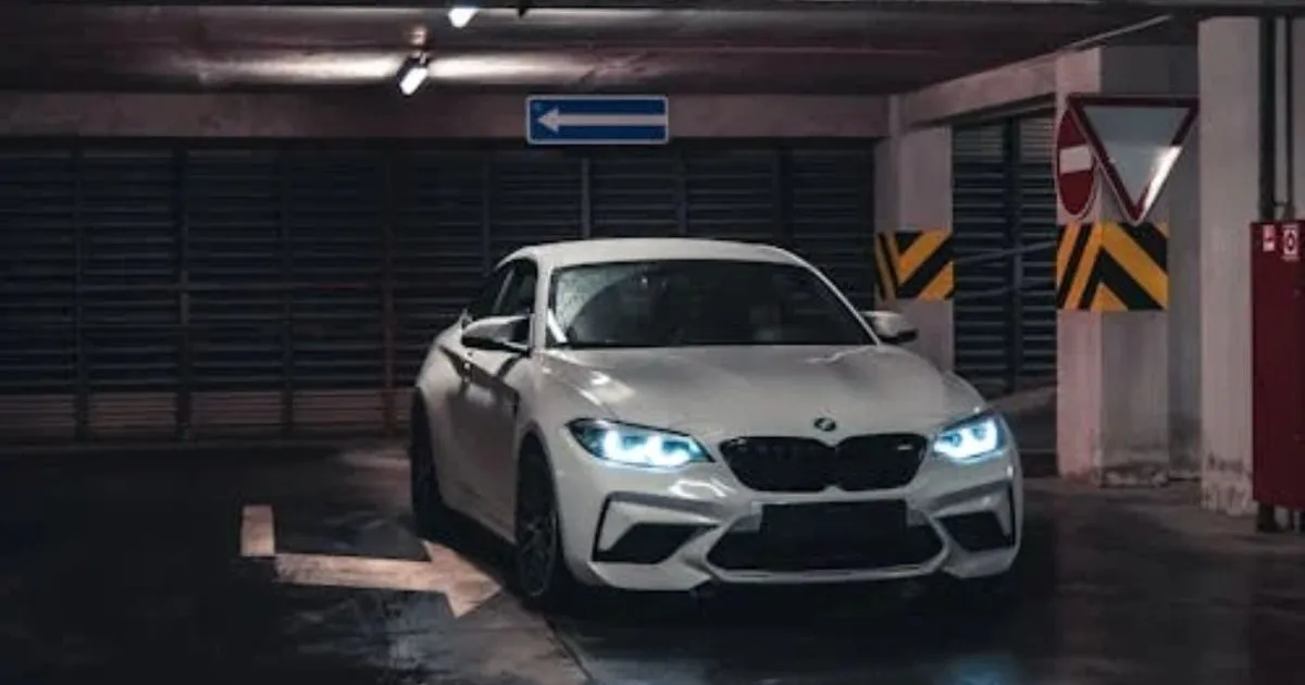 A White Car Parked In An Underground Parking Garage Having Its Head Lights On A White Car Parked In An Underground Parking Garage Having Its Head Lights On