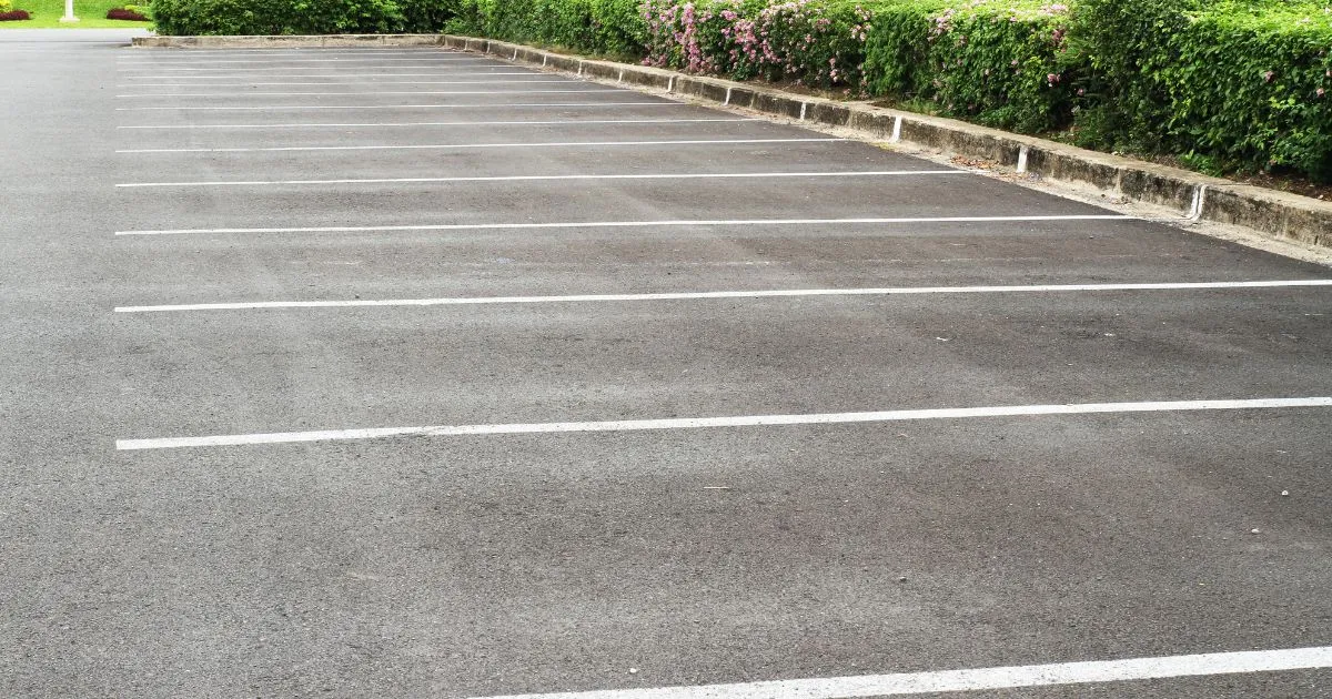 Empty Outdoor Parking Spaces With Green Landscape