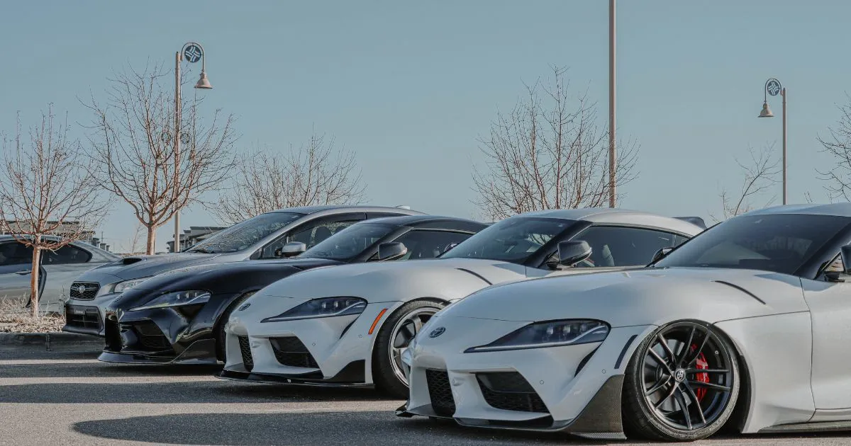 Four Luxury Vehicles Parked In An Uncovered Car Park