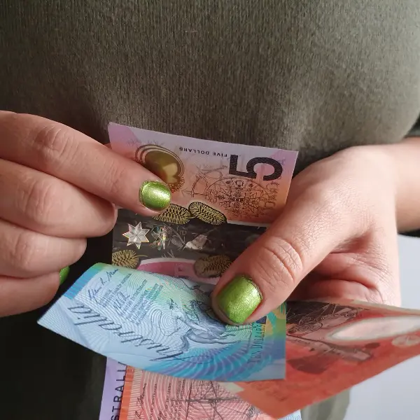 Hands counting Australian banknotes representing the earnings you can generate when you rent out your garage.
