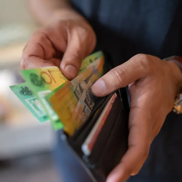 Hands taking cash from a wallet illustrating the savings and earnings available when you rent out your parking space.