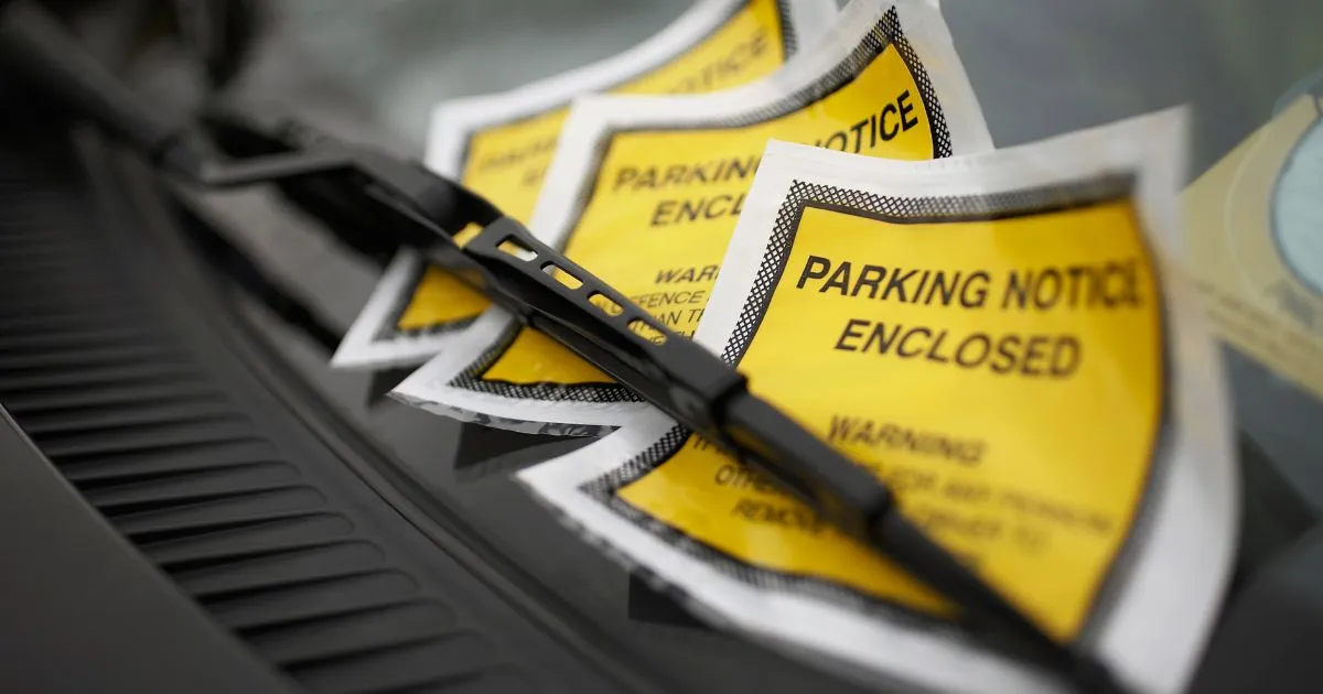 Multiple Parking Violation Notices On The Windshield Of A Car