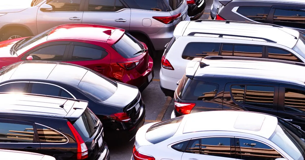 Multiple Vehicles Parked In An Outdoor Parking Space Under Sunlight