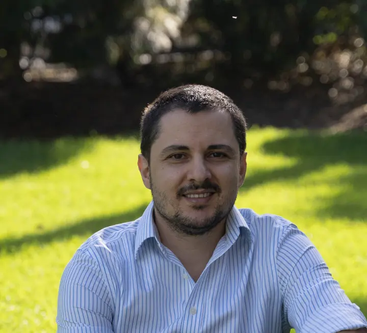 A man in a blue shirt sitting on the grass