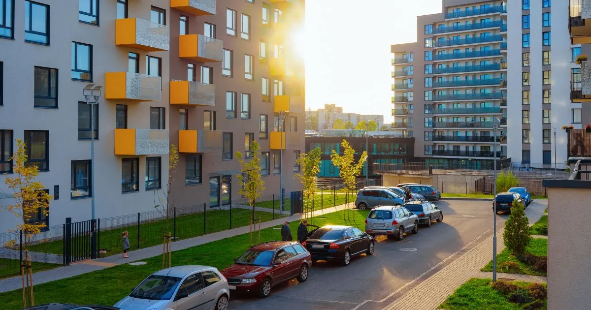 The Parking Area Of An Apartment Complex With Many Parked Vehicles
