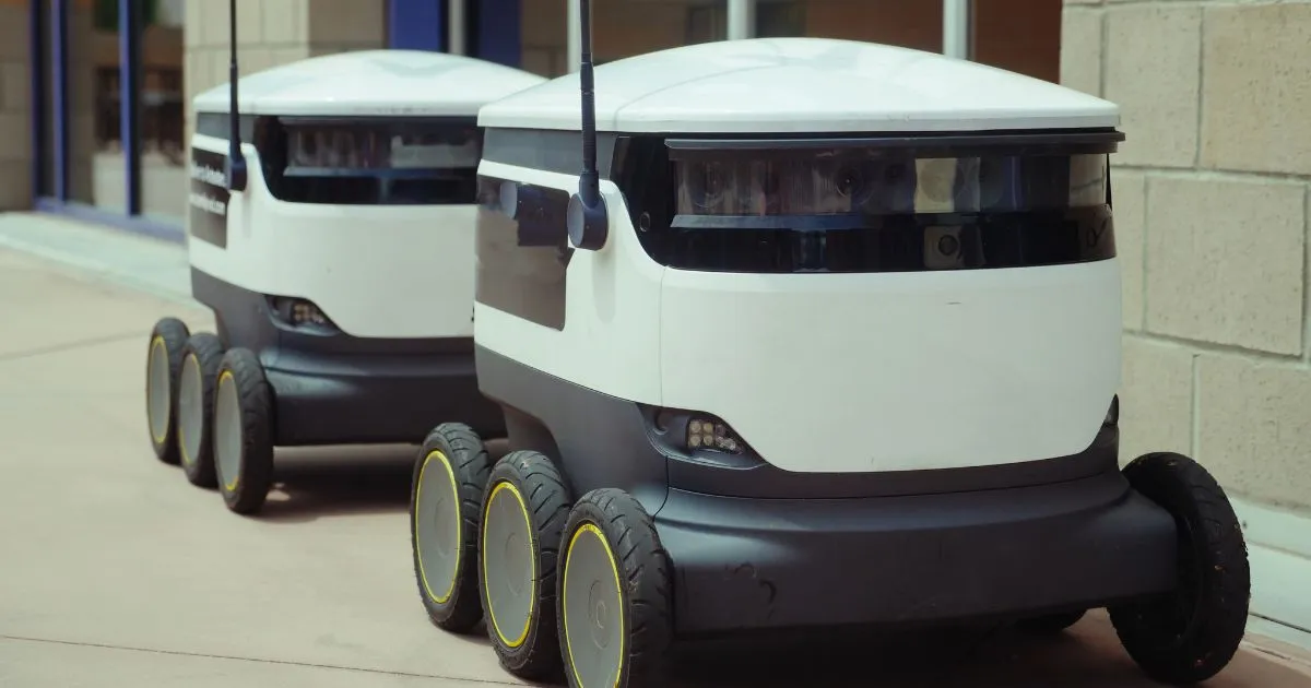Two Autonomous Vehicles Parked Outside A Building Two Autonomous Vehicles Parked Outside A Building