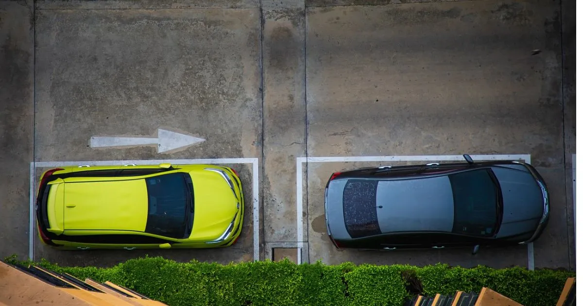 Two Cars Parked On The Street In The Designated Parking Area