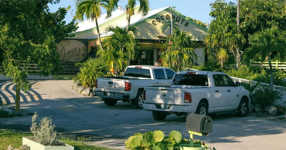 Two White Vehicles Parked In The Parking Area Of A Renowned Park
