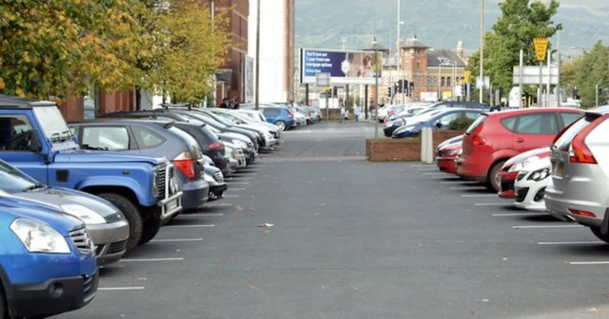 Various Vehicles Parked On Both Sides Of The Street With Driveway In The Middle